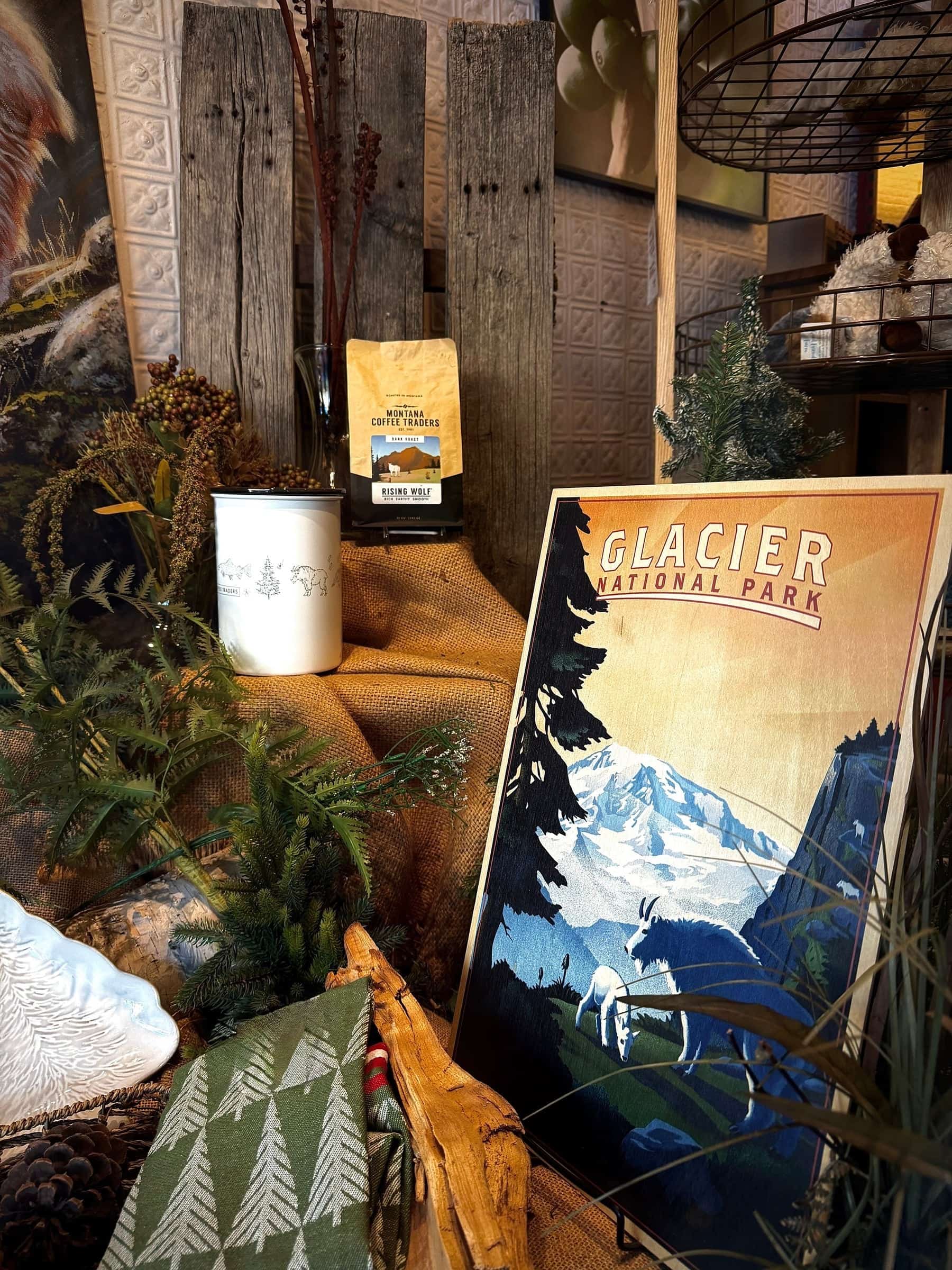 Lodge style lobby corner with reclaimed wood, greenery and a vintage Glacier National Park poster