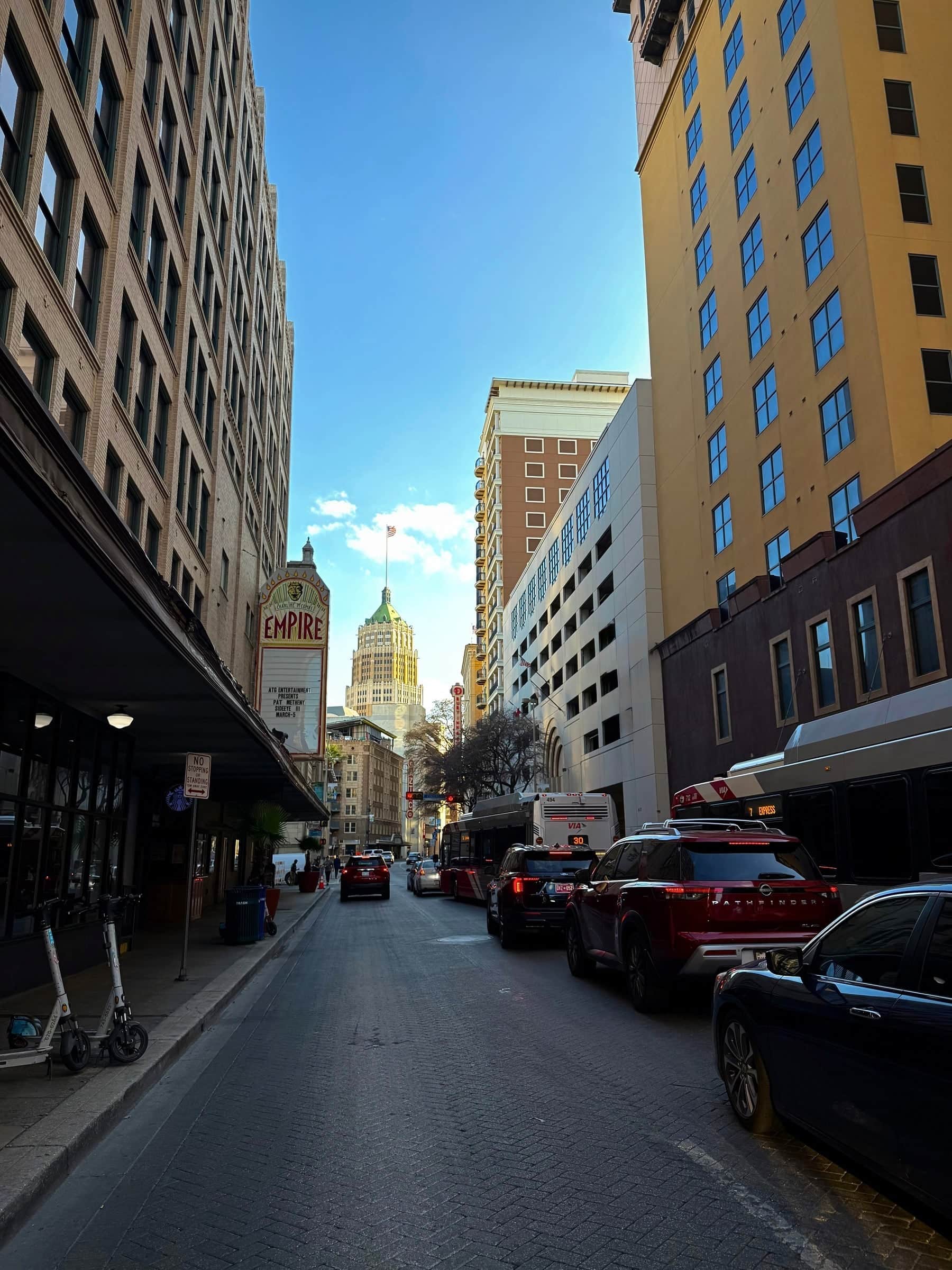 Downtown San Antonio street with the vertical Empire theater sign and a domed tower at the end of the block