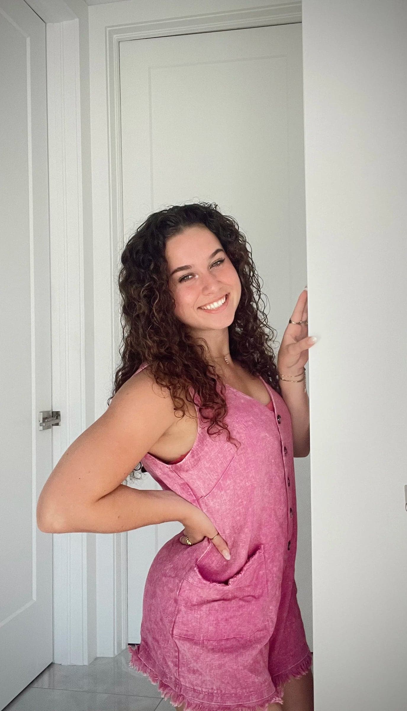 Sadie Santerelli, founder of Zyre Collective, smiling in a sunlit doorway